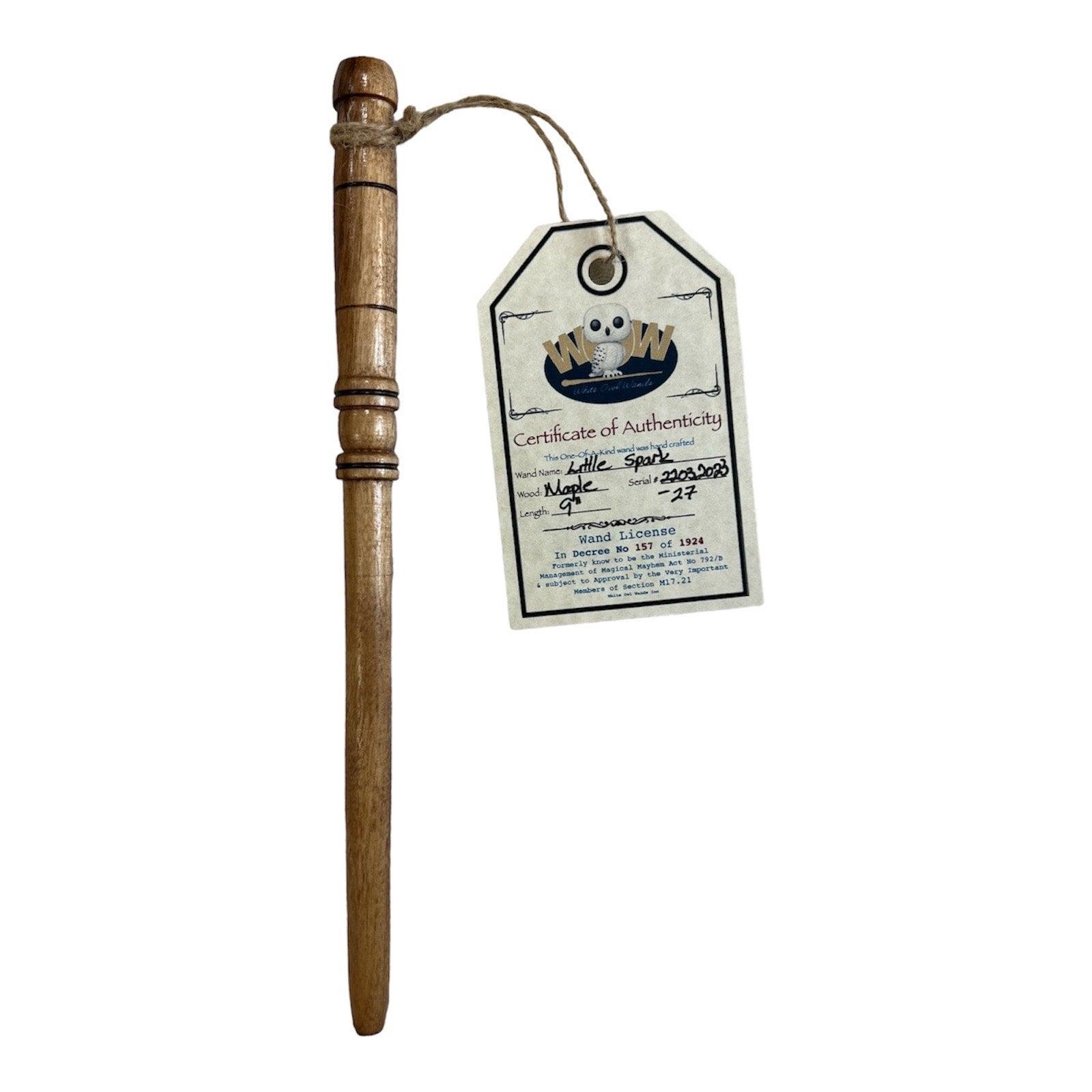 Handcrafted wooden wand with a White Owl Wands tag