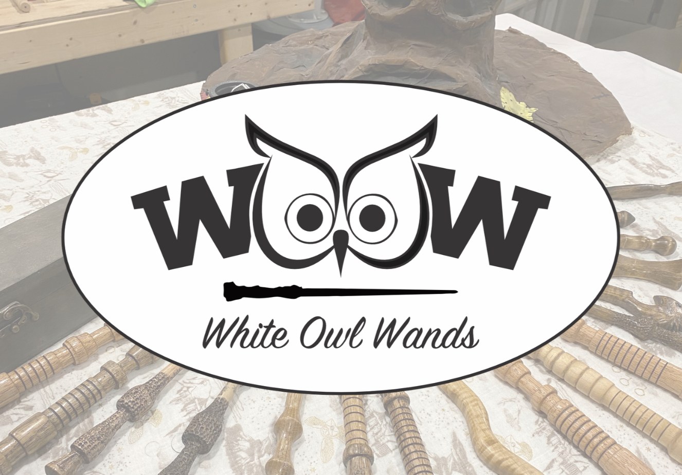 White Owl Wands branding over a display of handcrafted wooden wands